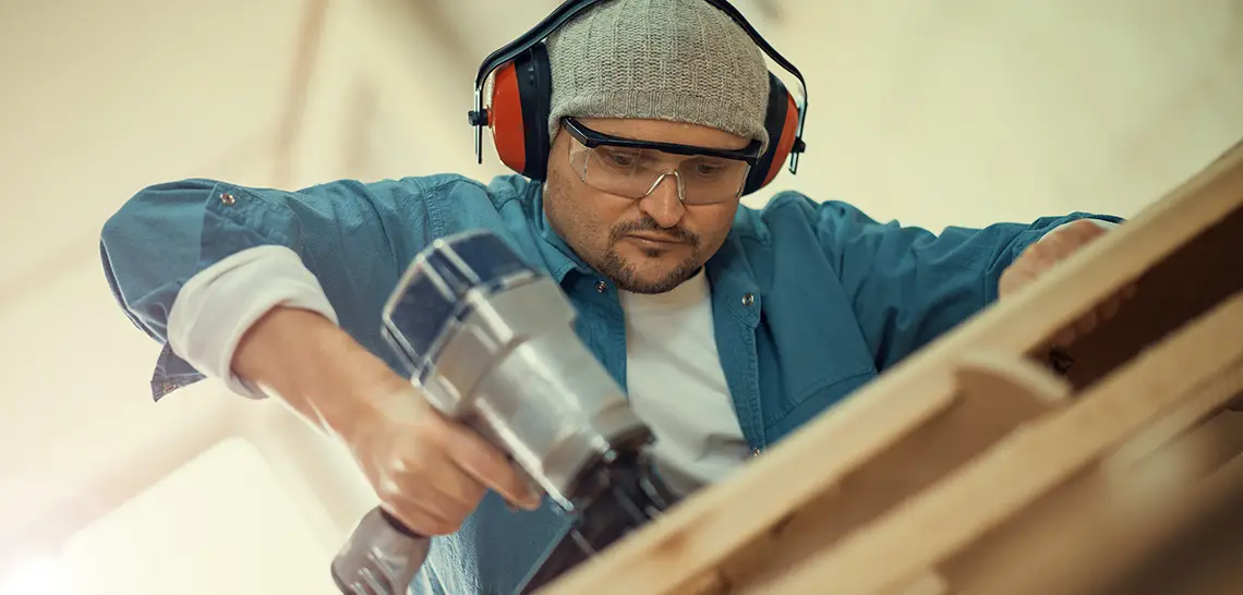 Carpenter using a pneumatic nail gun